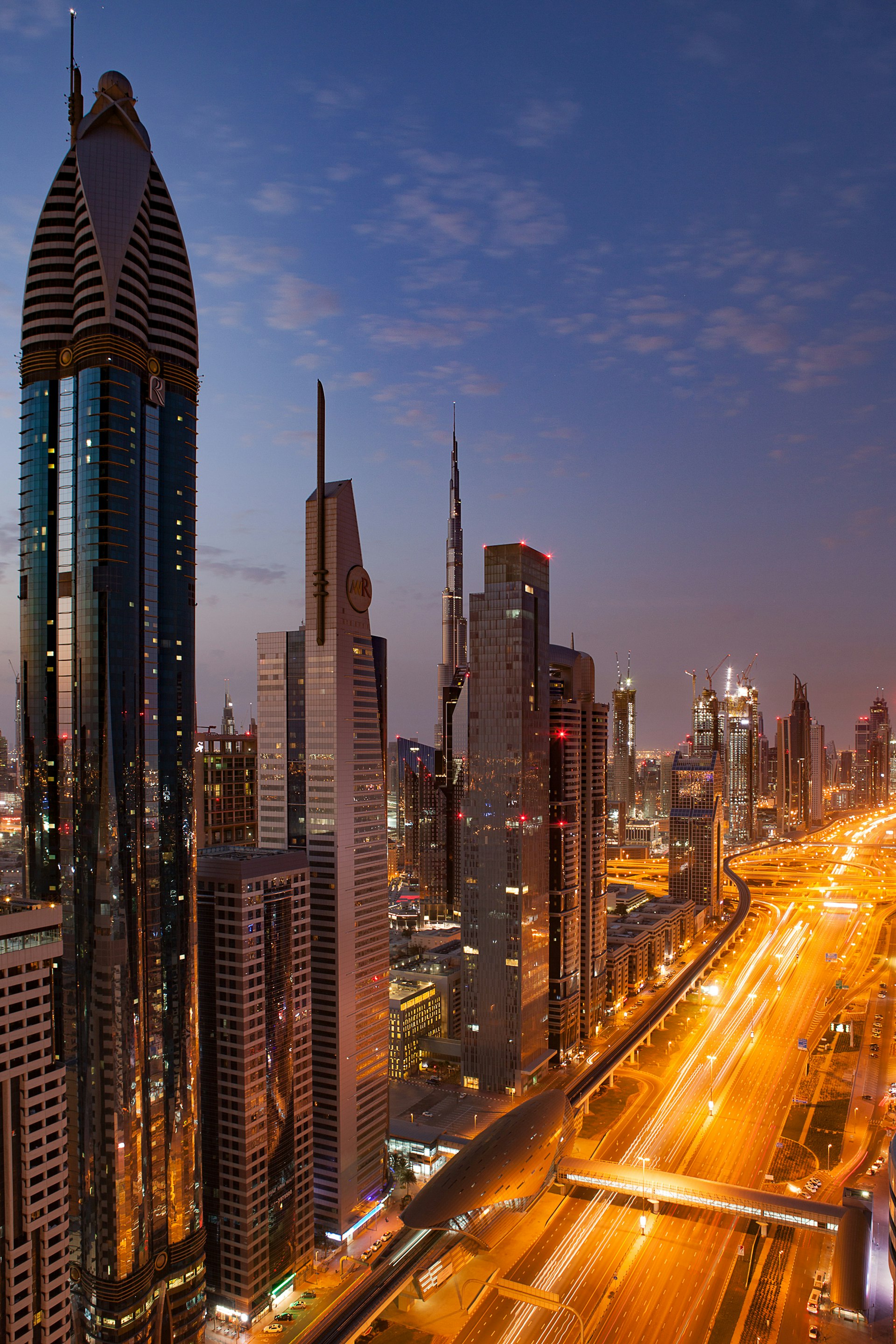 Dubai skyline along Sheikh Zayed Road at dusk with the Burj Khalifa